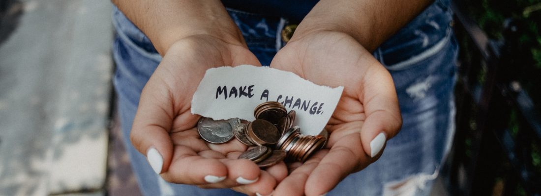 person showing both hands with make a change note and coins